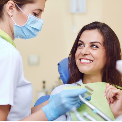 Dentist assisting a smiling patient in a dental office, highlighting the supportive environment for those considering dental implants.